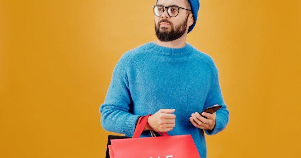 Homem De Suéter Azul Segurando Um Saco De Papel Vermelho