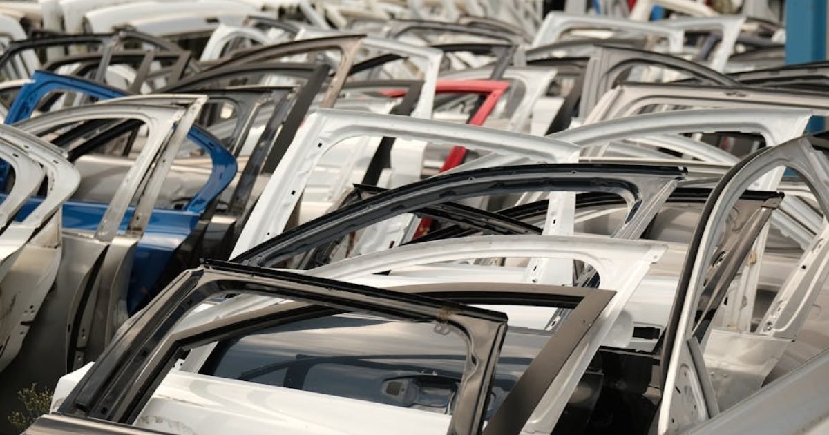 Diversas portas de carros de cores variadas dispostas em um ferro-velho.
