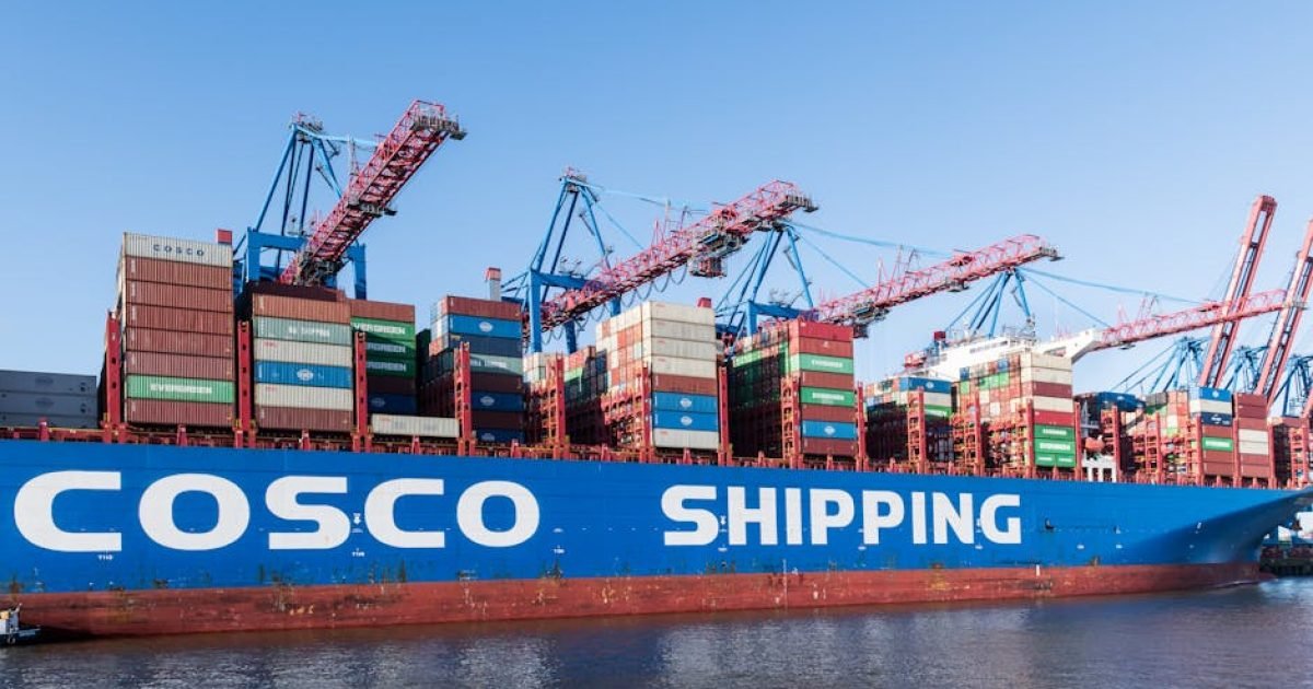 Grande navio de carga no porto de Hamburgo com guindastes carregando contêineres.